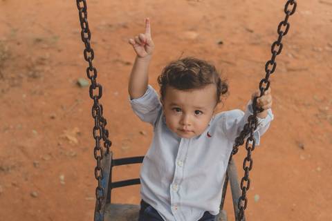 menino no balanço do parquinho'