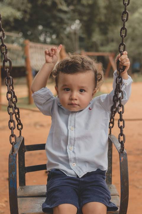 menino no balanço do parquinho'