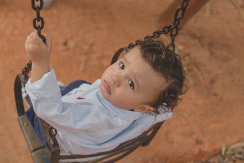 menino no balanço do parquinho'