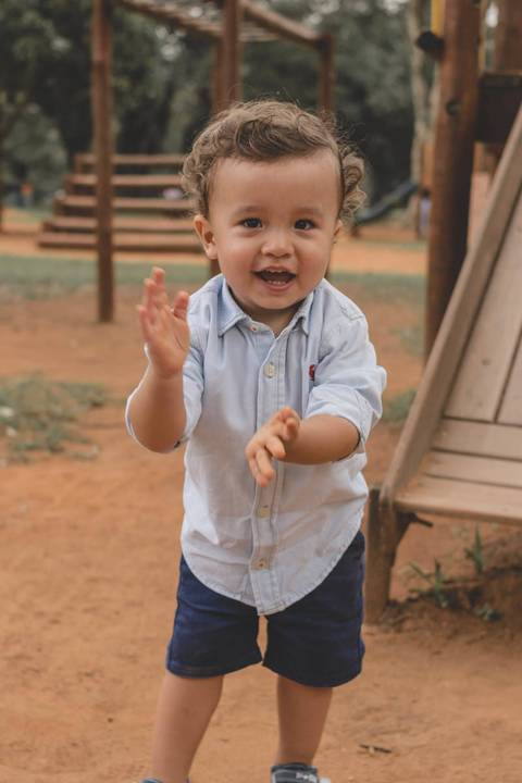 menino brincando na terra do parquinho'