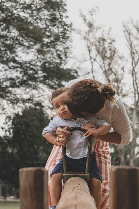 mãe e filho na gangorra no parquinho'