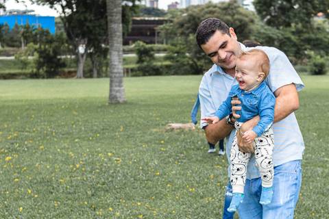 Pai com filho bebê no colo'