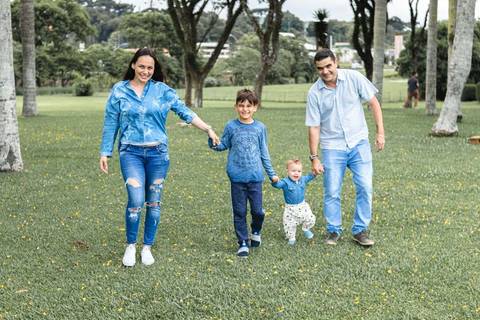 Família caminhando de mãos dadas no parque '