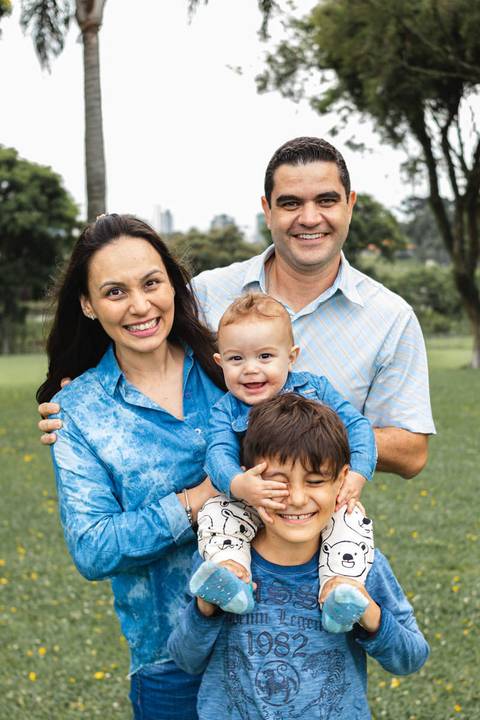 família abraçada brincando no parque '