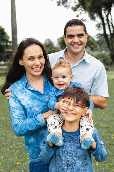 família abraçada brincando no parque '
