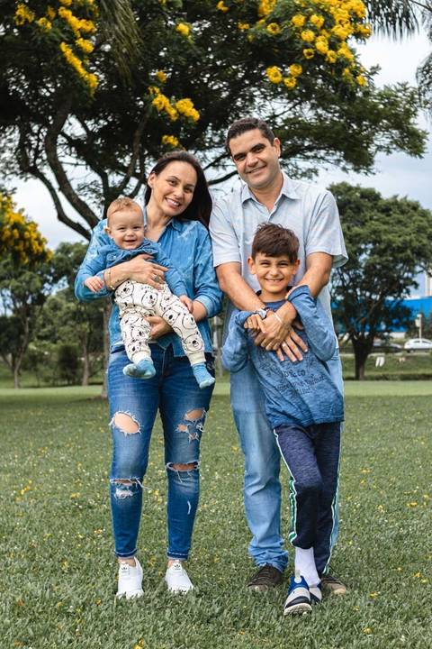 família abraçada brincando no parque '