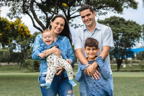 família abraçada brincando no parque '