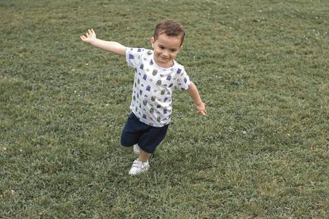 menino correndo de braços abertos no Parque '