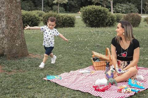 menino correndo de braços abertos no Parque '