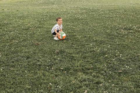 menino jogando bola no parque '
