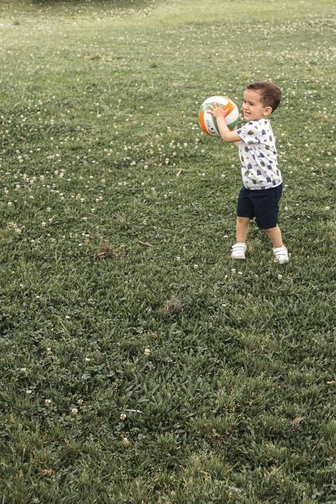 menino jogando bola no parque '