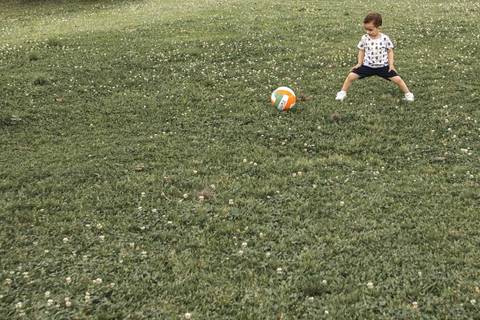 menino jogando bola no parque '