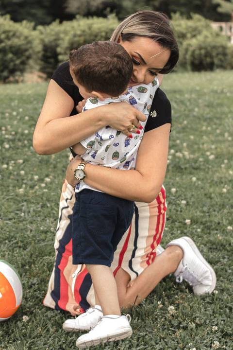 mãe abraçando filho no colo no parque '