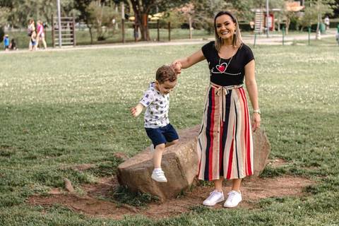 mãe e filho brincando de pular no parque '