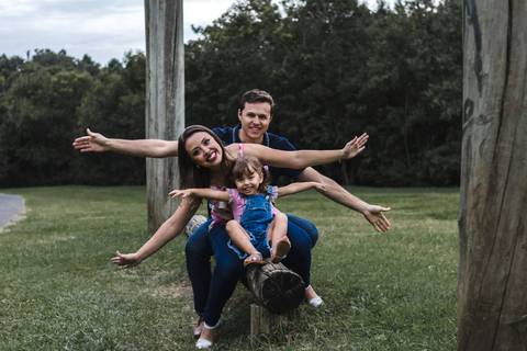 menina brincando com os pais no parque '
