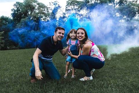 menina brincando com os pais no parque '