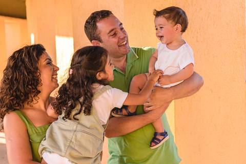 pai, mãe, filha e filho brincando no '