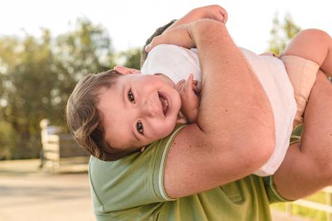 pai brincando com filho bebê menino no colo'