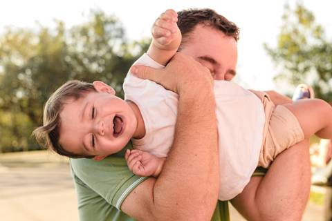 pai brincando com filho bebê menino no colo'