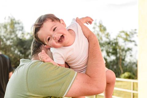 pai brincando com filho bebê menino no colo'