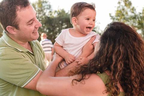 pai e mãe brincando com filho bebê menino no colo'