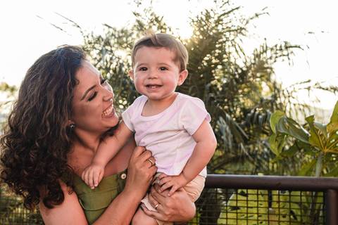 Mãe sorrindo com filho bebê no colo '