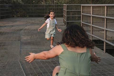 menina correndo para abraçar a mãe '