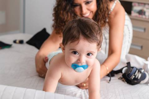 mãe trocando a roupa do filho bebê '