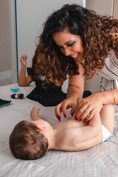 mãe trocando a roupa do filho bebê '