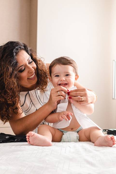 mãe trocando a roupa do filho bebê '