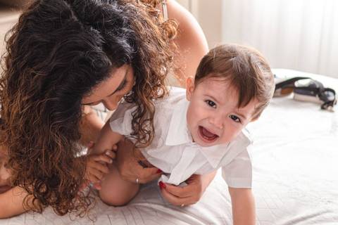 mãe trocando a roupa do filho bebê '