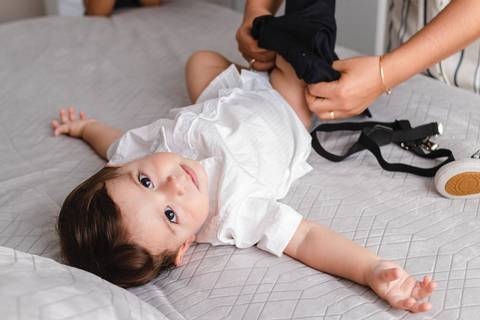 mãe trocando a roupa do filho bebê '