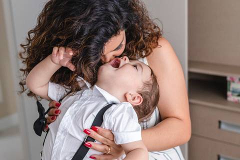 mãe trocando a roupa do filho bebê '