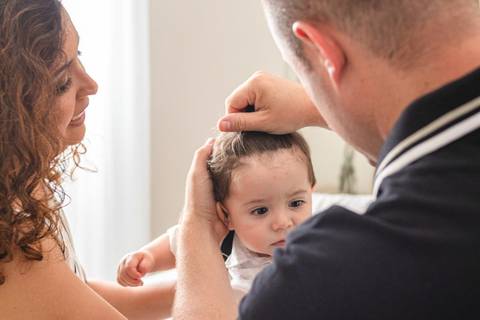 pai arrumando cabelo do  filho bebê '