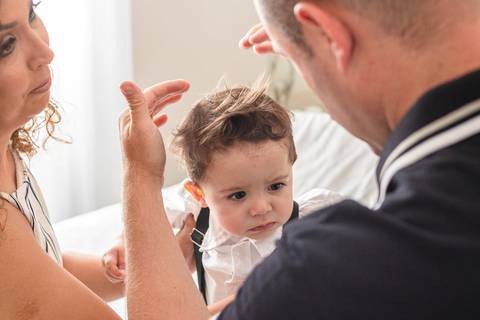 pai arrumando cabelo do  filho bebê '