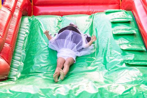 menina descendo no escorrega inflável '