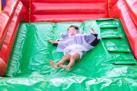 menina descendo no escorrega inflável '