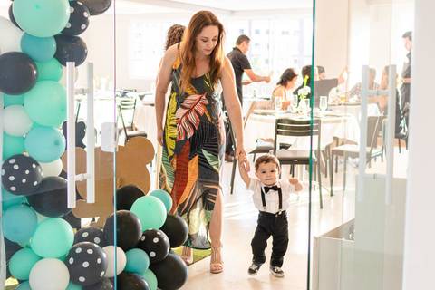 bebê passeando de mãos dadas com a tia no salão de festas '