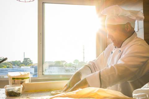 pizzaiollo fazendo pizza no pôr do sol'