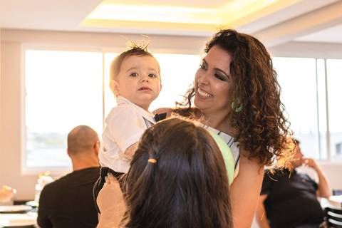 mãe com bebê no colo na festa de um ano '