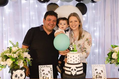 padrinhos com bebê no colo na mesa de aniversário de um ano '