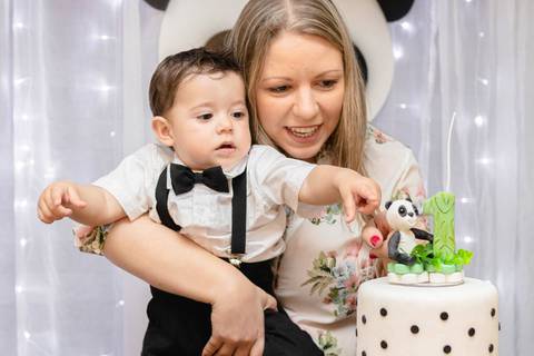madrinha com bebê brincando no bolo de aniversário de um ano '