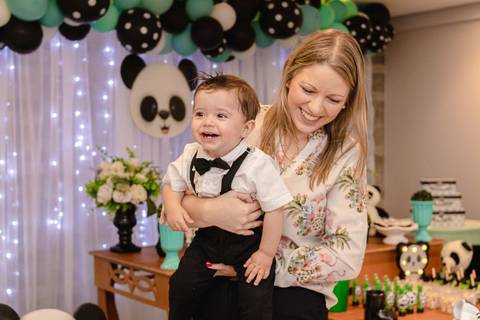 madrinha com bebê no colo na mesa de aniversário de um ano '