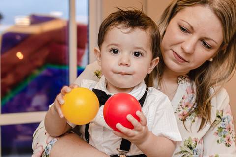 madrinha com bebê no colo na mesa de aniversário de um ano '