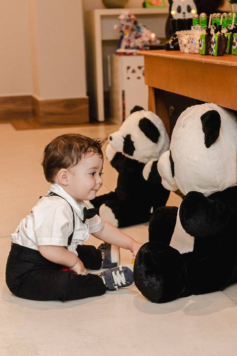 bebê brincando com urso panda de pelúcia de enfeite da decoração da festa de um ano '