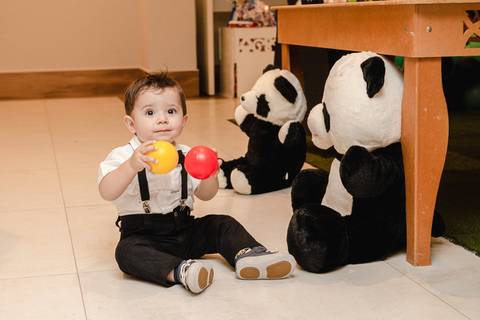 bebê brincando com urso panda de pelúcia de enfeite da decoração da festa de um ano '