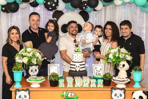 família reunida na mesa de aniversário de um ano com tema de urso panda '