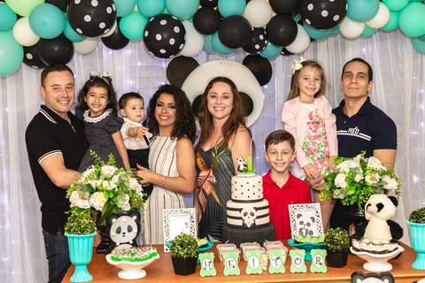 família reunida na mesa de aniversário de um ano com tema de urso panda '