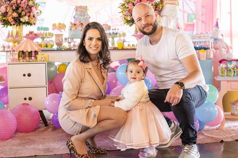 Mãe, Pai e Filha na frente da Decoração de Festa de aniversário Infantil de um ano da Helena, filha da @blogbytali com tema de Circo '