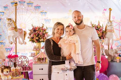 pai, filha e avó na frente da Decoração de Festa de aniversário Infantil de um ano da Helena, filha da @blogbytali com tema de Circo '